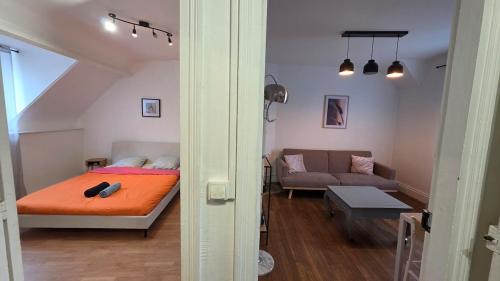 a small room with a bed and a couch at T2 proche du CH d'Arras in Sainte-Catherine