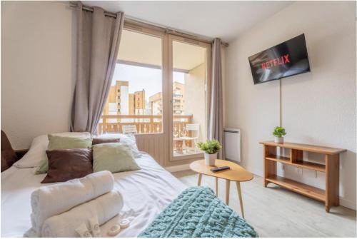 ein Wohnzimmer mit einem Bett und einem Fenster in der Unterkunft Ski In-Out - Heart of Val Thorens Beautiful View, WiFi in Val Thorens