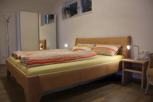 a bedroom with a wooden bed with two pillows at Haus Beilerstädtle in Oppenau