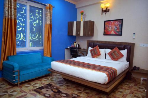 a bedroom with a bed and a blue couch at Hotel KB Palace in Varanasi