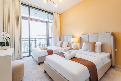 two beds in a hotel room with a large window at Champions' Apartment - Balcony Sunsets - Rooftop Pools - Modern Oasis - Family Heaven - Full Canal Views - 2 min walk from Space42 Arena in Abu Dhabi