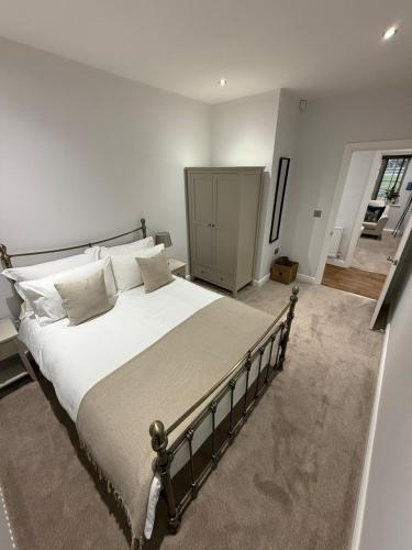 WarmsworthにあるWarmsworth Mewsの白いシーツと枕が付いた大きなベッドのある寝室