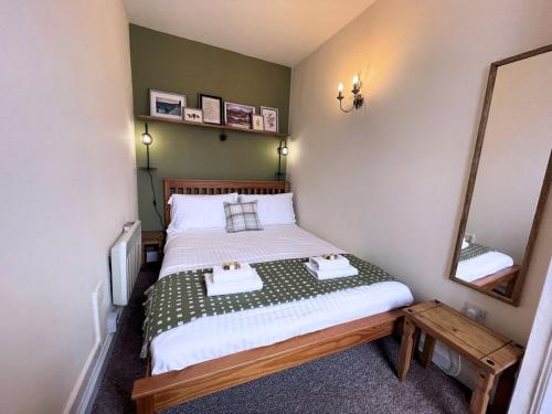 a small bedroom with a bed and a mirror at Pass the Keys Cosy Romantic Getaway with Hot Tub in Whithorn