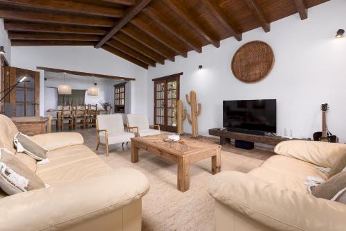 a living room with two couches and a coffee table at Home2Book Serenity Villa with Private Pool in Casillas del Ángel