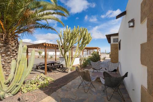 a patio with chairs and a gazebo and cactus at Home2Book Serenity Villa with Private Pool in Casillas del Ángel