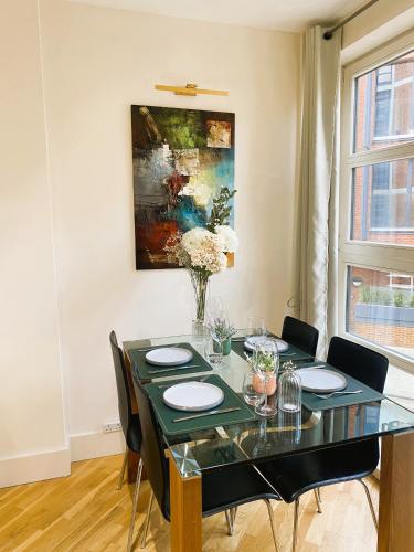 a dining room with a table with chairs and a painting at Central London Flat ideal for Shopping and Big Ben in London
