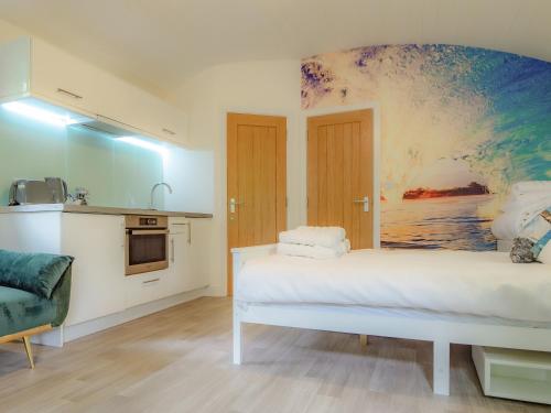 a bedroom with a white bed and a painting on the wall at Owl - Uk43447 in Hayle