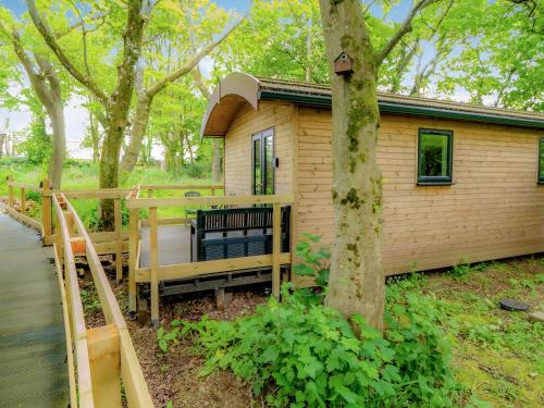 a small house with a deck and a tree at Owl - Uk43447 in Hayle