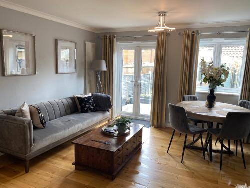 a living room with a couch and a table at Modern house easy access Norwich city and broads in Spixworth