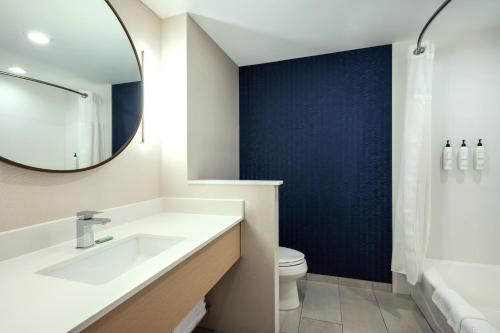 a bathroom with a sink and a mirror and a toilet at Fairfield by Marriott Inn & Suites North Bay in North Bay