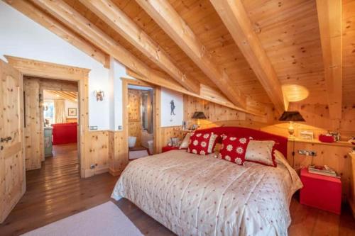 a bedroom with a large bed and wooden ceilings at Family and Wellness Residence Ciasa Antersies in San Cassiano