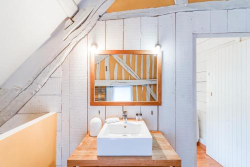 ein Badezimmer mit einem weißen Waschbecken und einem Spiegel in der Unterkunft L'Esprit Loft - Logement atypique pour 12 pers in Honfleur