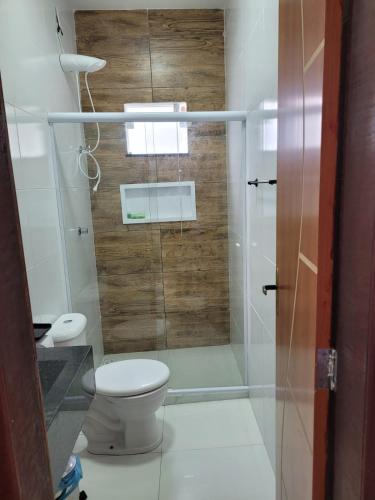 een badkamer met toilet en glazen douche bij Casa Brisa do Mar in Camaçari