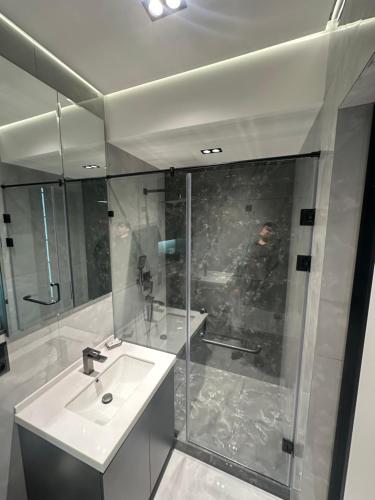 ein weißes Badezimmer mit Waschbecken und Dusche in der Unterkunft TASHKENT CITY PREMIUM NRG U tower 8 floor, 106 in Taschkent