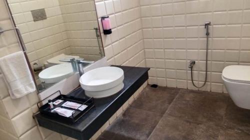 a bathroom with a toilet and a sink and a mirror at HOTEL SAPTARSHI in Bānkura