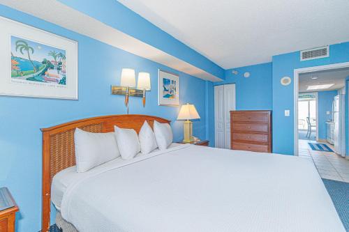a bedroom with a large bed with blue walls at Spacious 1 BR Condo-Breathtaking Oceanfront Views! Bay Watch 706 in Myrtle Beach
