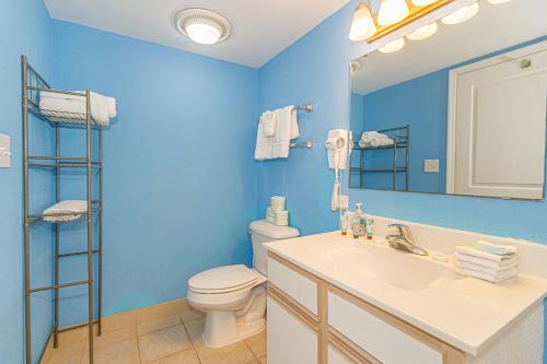 a blue bathroom with a toilet and a sink at Spacious 1 BR Condo-Breathtaking Oceanfront Views! Bay Watch 706 in Myrtle Beach