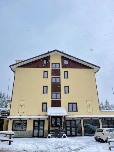 a large building with snow in front of it at Hotel Genevris Cinq in Sauze d'Oulx