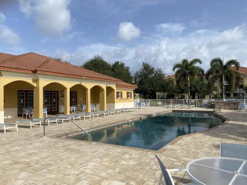 Pine ManorResidence Condo II的带椅子的游泳池和一栋建筑