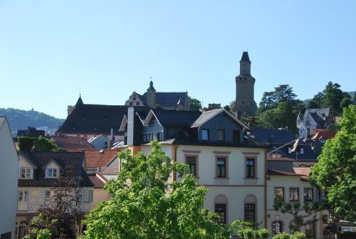 a white building with a town in the background at Posthaus Hotel Residenz in Kronberg im Taunus