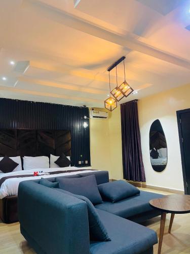 een woonkamer met een bank en een bed bij The Majj Hotel Sapele in Sapele