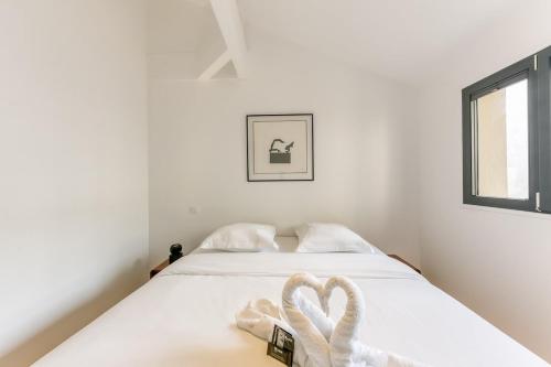 ein weißes Bett mit zwei herzförmigen Handtüchern darauf in der Unterkunft Designer loft 5 minutes from Paris in Bagnolet