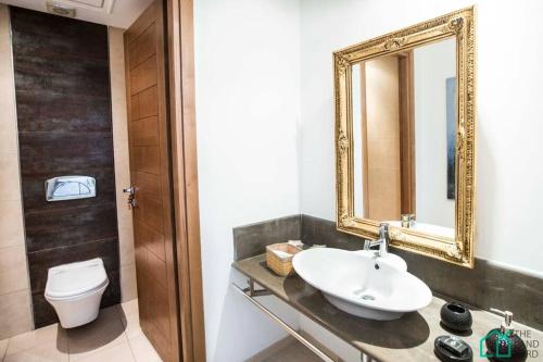 a bathroom with a sink and a mirror and a toilet at Le Premium Central luxueux et très confortable in Dār Şāliḩ Bey