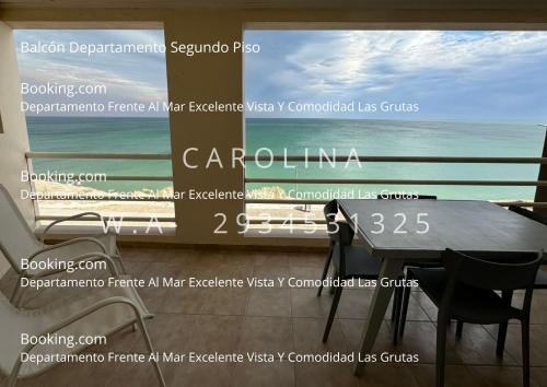 Un mural de pared con una escena del océano, una mesa y sillas. en VISTA AL MAR Departamento Frente Al Mar Excelente Vista Y Comodidad Las Grutas, en Las Grutas