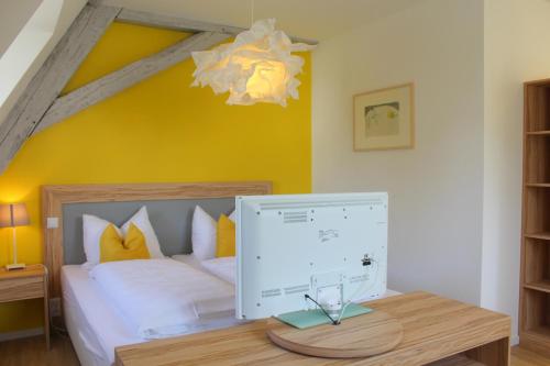 a bedroom with a bed and a desk with a computer on it at Gasthaus Schiff in Freiburg im Breisgau