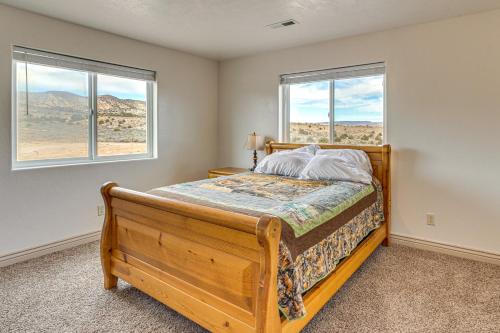 a bedroom with a bed and two windows at Near Dinosaur Natl Monument! High Desert Hideaway in Naples