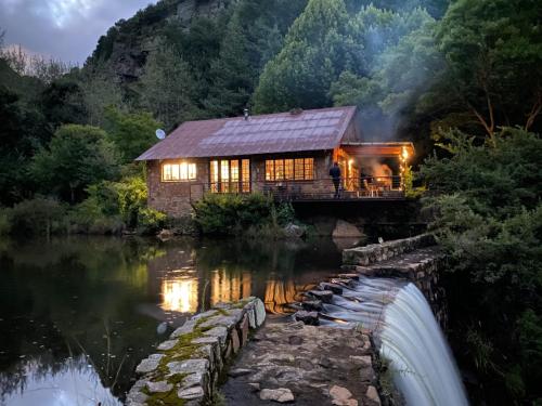a log cabin on a bridge over a river at Migrate Portfolio in Dullstroom