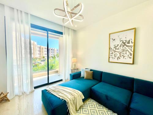 a blue couch in a living room with a large window at NEW bright and luxurious 2 bedrooms in Rd Malaga in Sidi Daoud