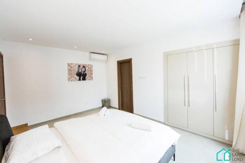 a white room with a table and white cabinets at Sunset 204 Luxury 2 bedrooms with Gym in Carthage