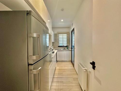 a kitchen with a refrigerator and a hallway at Villa Jade appartement neuf avec jardin in Dar el Haj Ahmed Souid