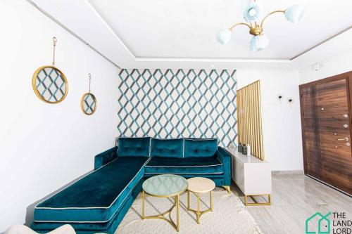 a living room with a blue couch and two tables at New 1 bedroom with swimming pool next to Lac 2 in El Aouina Station