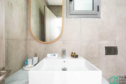 a bathroom with a white sink and a mirror at New 1 bedroom with swimming pool next to Lac 2 in El Aouina Station