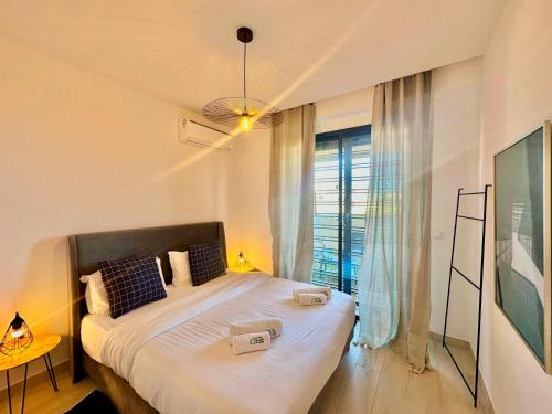 a bedroom with a large bed with a window at C1 Jade new cozy 1 bedroom with garden in Dar el Haj Ahmed Souid