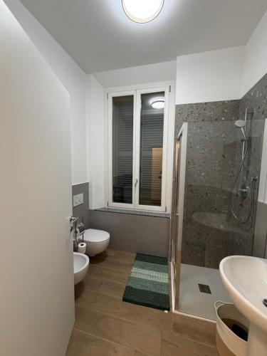 Un baño con ducha, inodoro y lavabo. en Adriano Space, en Módena