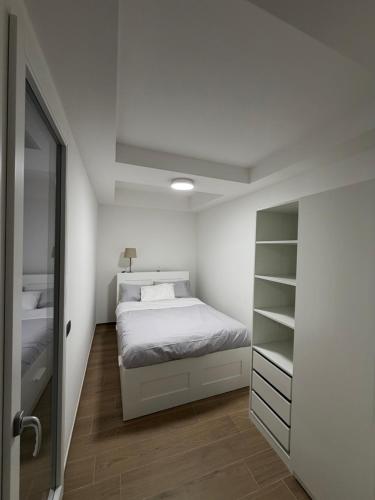 Un dormitorio con una cama y un vestidor. en Adriano Space, en Módena