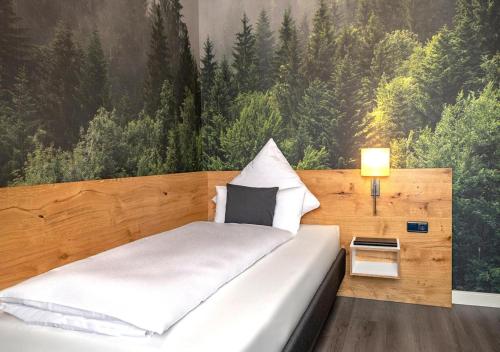 a bedroom with a bed with a large painting on the wall at Boutique Hotel Zum grünen Baum in Alzenau in Unterfranken