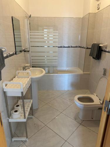 a bathroom with a toilet and a sink and a tub at Condominio atlantico ll in Praia