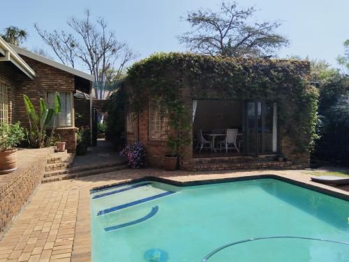 a swimming pool in the backyard of a house at Feather Tree Bed and Breakfast in Centurion