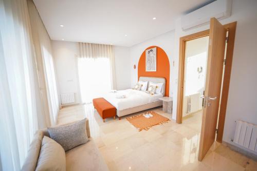 a bedroom with a bed with an orange headboard at Villa Apollon: Seaside and luxurious in El Haouach