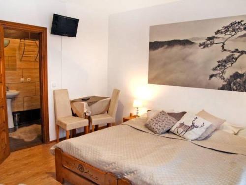 a bedroom with a bed and a desk and a chair at Salamonówka in Szlachtowa