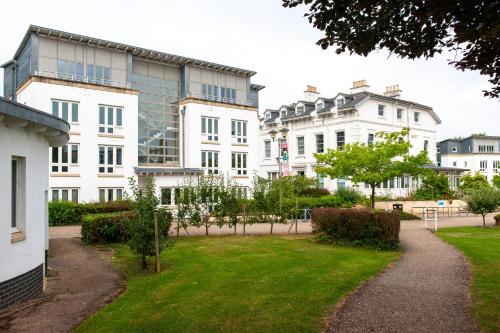 een groot wit gebouw met een gazon ervoor bij Villas at Park Campus in Cheltenham