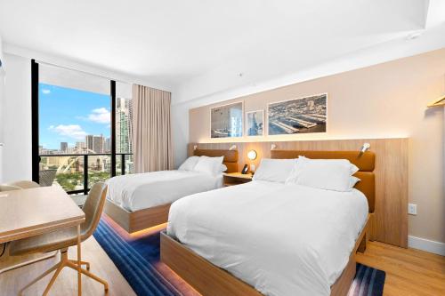 a hotel room with two beds and a desk and a desk at Gale Hotel Stay - Modern Condo Near the Bay in Miami