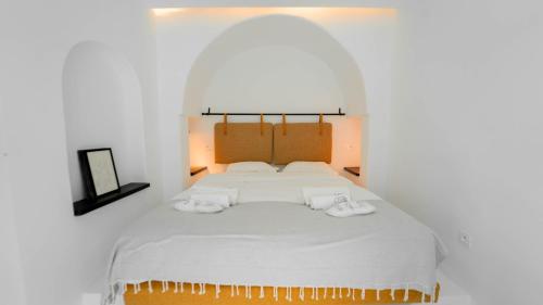 El HaouachAurora La Marsa Jacuzzi – Modernité Charme的一间卧室配有一张带白色床单和拖鞋的大床。