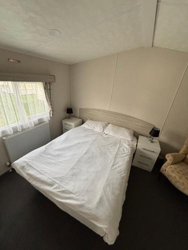 Un dormitorio con una cama blanca y dos mesitas de noche. en Seaview Holiday Rentals - Hailsham, en Chestfield