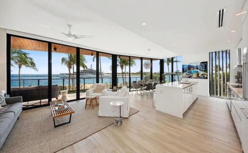 パーム・ビーチ・ショアーズにあるCozy Three-Bedroom Waterfront Apartment with Scenic Viewsの白い家具付きのリビングルームが備わり、海の景色を望めます。