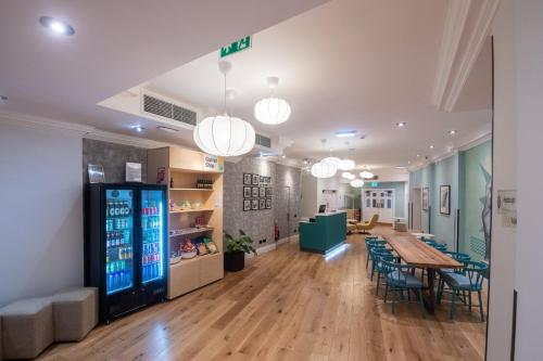 a room with a table and chairs and a drink machine at Garner Hotel Reading City Centre, an IHG Hotel in Reading
